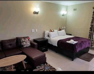 a hotel room with a bed and a couch at Victoria Guest Lodge in Bellville