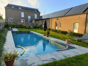 a swimming pool in the backyard of a house at B&B Het Doctershoes in Kinrooi