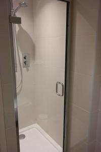a bathroom with a shower with a glass door at The Alma Rooms in London