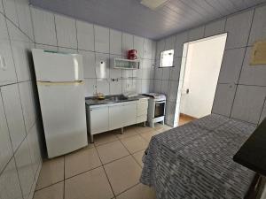 a small kitchen with a refrigerator and a sink at Casa no Centro de Cabo Frio in Cabo Frio