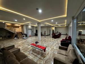 ein großes Wohnzimmer mit einem Sofa und einem Tisch in der Unterkunft Grands Orchid Hotel in Lahat