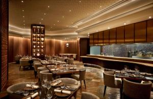 a restaurant with tables and chairs and a bar at JW Marriott Mumbai Juhu in Mumbai