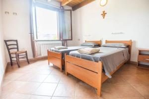 two twin beds in a room with a window at OASI FRANCESCANA SANT'IGNAZIO DA LACONI in Làconi