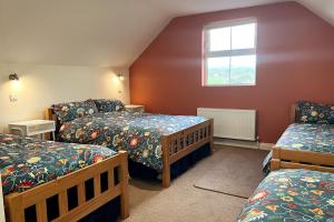 Murroogh的住宿－Into The Burren，一间卧室设有三张床和窗户。