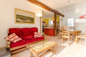 a living room with a red couch and a table at La ferme des chartreux in Messon