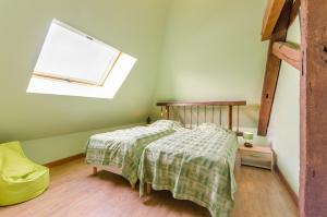 a small bedroom with a bed and a window at La ferme des chartreux in Messon