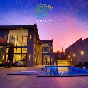 a villa with a swimming pool in front of a building at Nirvana Chalets in Jerash