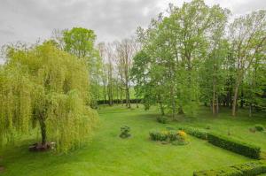 einen Garten mit Bäumen und Blumen auf einem Feld in der Unterkunft Le chateau de crespy 