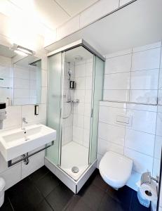uma casa de banho com um chuveiro, um WC e um lavatório. em Hotel Royal Luzern em Lucerna