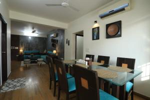 a dining room and living room with a table and chairs at Banipark Service Apartment in Jaipur