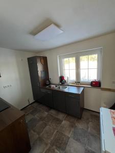 an empty kitchen with a sink and a refrigerator at Ferienhaus Melzower Waldhaus Montagewohnung in Melzow