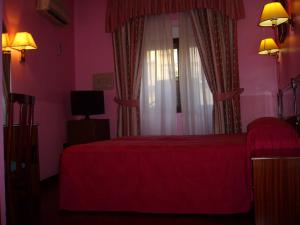 a bedroom with a red bed and a window at Hostal Centro Sol in Madrid
