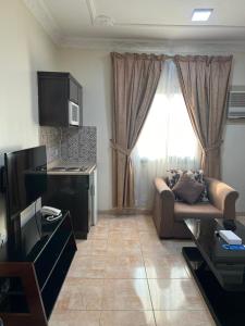 uma sala de estar com um sofá e uma janela em السعد للشقق المخدومة em Al Jubail