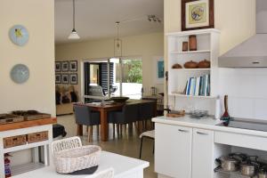 uma cozinha com armários brancos e uma sala de jantar em Rothersands 16 em Plettenberg Bay