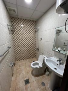 a bathroom with a toilet and a sink at السعد للشقق المخدومة in Al Jubail