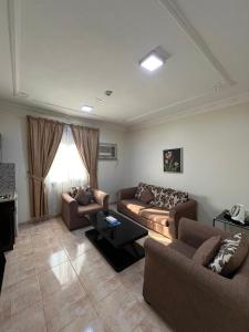 a living room with two couches and a table at السعد للشقق المخدومة in Al Jubail