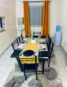 ein Esszimmer mit einem Tisch und einem gelben Tischtuch in der Unterkunft D15 in Mombasa