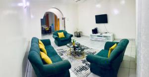 ein Wohnzimmer mit einem grünen Sofa und 2 Stühlen in der Unterkunft D15 in Mombasa