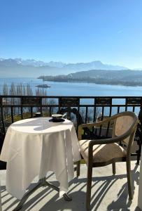 uma mesa e cadeira numa varanda com vista para a água em Hotel Royal Luzern em Lucerna