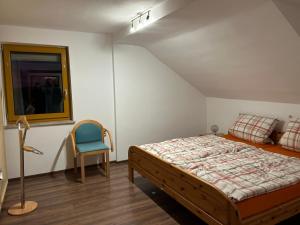een slaapkamer met een bed en een stoel erin bij Ferienwohnung Zucker in Grafenau