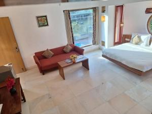 sala de estar con cama y sofá en The Chitvan Resort en Ajmer