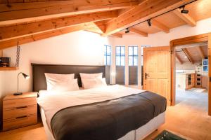 1 dormitorio con cama grande y techo de madera en Alpenhaus Oberstdorf en Oberstdorf