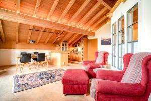 una sala de estar con 2 sillas rojas y una mesa. en Alpenhaus Oberstdorf, en Oberstdorf