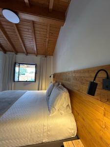 - une chambre avec un lit et un mur en bois dans l'établissement Quinta da Boavista, à Vila Nova de Milfontes