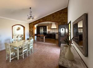 a dining room and living room with a table and chairs at Cómoda villa en la montaña in Gran Tarajal