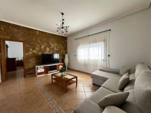a living room with a couch and a tv at Cómoda villa en la montaña in Gran Tarajal