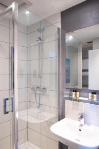 uma casa de banho com um chuveiro, um lavatório e um espelho. em Ship and Castle Hotel em Saint Mawes