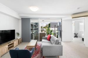 a living room with a couch and a tv at South bank Serviced Apartments in Brisbane
