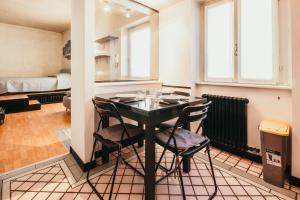 comedor con mesa negra y sillas en Appartamento Flaminia - Affitti Brevi Italia, en Varese