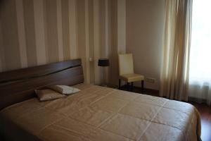a bedroom with a large bed and a window at Lyra Apartments in Druskininkai