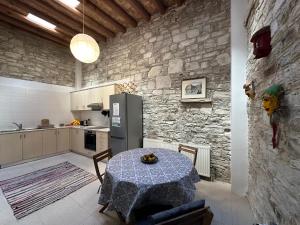 a kitchen with a table and a stone wall at Teleport Coliving Cyprus in Pano Lefkara
