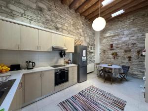 a kitchen with a table and a black refrigerator at Teleport Coliving Cyprus in Pano Lefkara