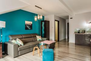 a living room with a couch and a blue wall at Apartamenty Widok in Szczawnica