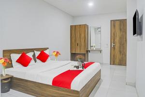 a bedroom with a large bed with red pillows at OYO Hotel Weekend Rooms in Surat