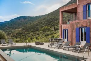 Luxurious Villa Nadoria, Ithaca Island في فاثي: منزل مع مسبح وكراسي وطاولة