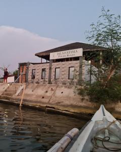 ein Boot im Wasser vor einem Gebäude in der Unterkunft Isla Fatima Private Resort in Guagua