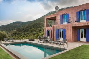 uma casa com uma piscina com uma montanha em Luxurious Villa Nadoria, Ithaca Island em Vathi