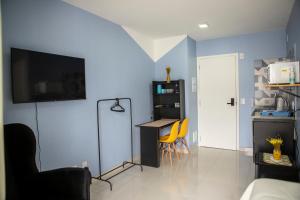 a living room with a table and a blue wall at Blue Liberdade in São Paulo