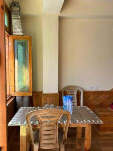 a wooden table with chairs and a table and a table and a table and chairs at Aarav Homestay in Kalpa