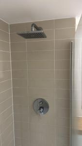 a shower with a faucet on a tiled wall at 2BR/2BA Gem with Private Balcony in London