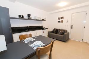 a kitchen and living room with a table and chairs at Morada Clariana in Curitiba