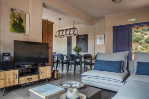 uma sala de estar com um sofá e uma televisão em Luxurious Villa Nadoria, Ithaca Island em Vathi