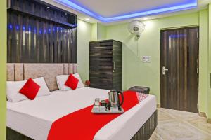 um quarto de hotel com uma cama com um cobertor vermelho em OYO Tulsi Angan em Dānāpur