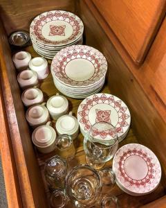 a drawer full of plates and bowls and glasses at Chalés Altos Da Montanha - Mont Blanc in Bom Jardim da Serra
