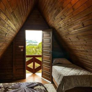 a attic room with a ladder leading to a window at Chalés Altos Da Montanha - Mont Blanc in Bom Jardim da Serra