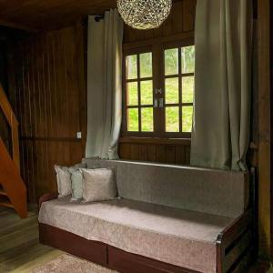 a large bed in a room with a window at Chalés Altos Da Montanha - Mont Blanc in Bom Jardim da Serra +3 photos